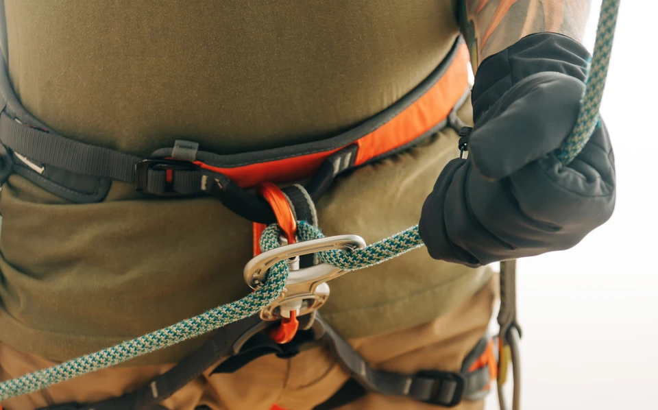 Personne en équipement de protection individuelle effectuant des travaux en hauteur sur structure métallique