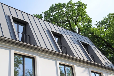 Deux ouvriers équipés de harnais de sécurité effectuent des travaux de nettoyage ou maintenance sur la façade d'un immeuble moderne multi-étages
